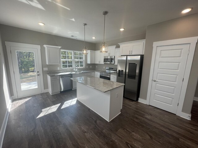 kitchen featuring a center island, a sink, appliances with stainless steel finishes, and white cabinets