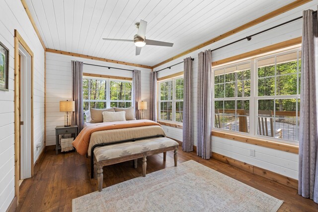 bedroom with hardwood / wood-style floors, baseboards, ceiling fan, wooden walls, and wooden ceiling