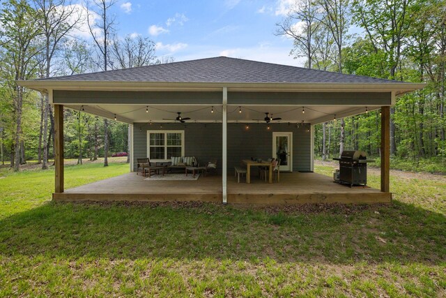 back of property featuring ceiling fan, roof with shingles, an outdoor hangout area, and a deck