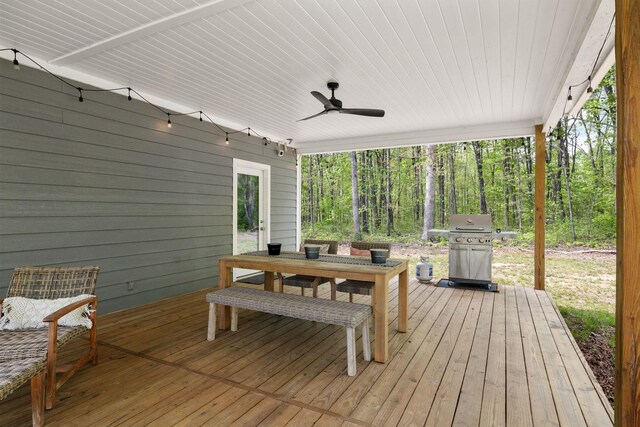 wooden deck with area for grilling, a ceiling fan, and outdoor dining area