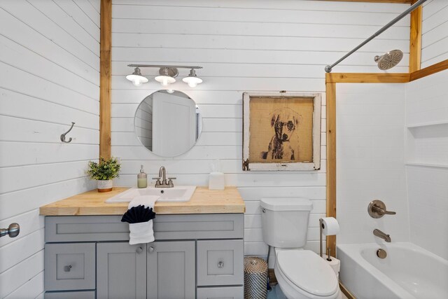 full bathroom featuring wooden walls, toilet, washtub / shower combination, and vanity