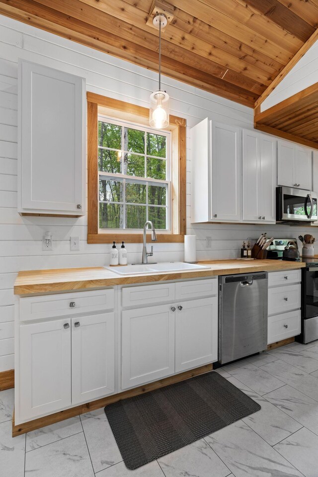 kitchen featuring a sink, wooden counters, marble finish floor, stainless steel appliances, and wooden ceiling