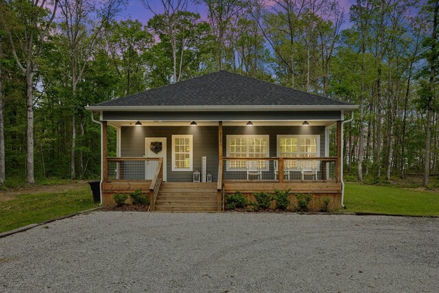 bungalow-style home with a porch and roof with shingles