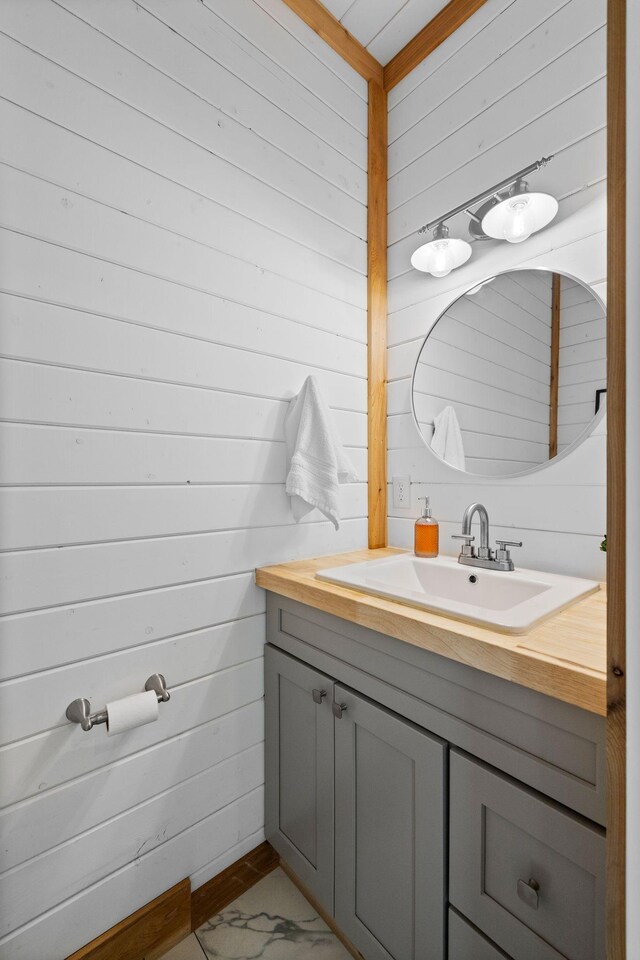 bathroom featuring vanity and wood walls