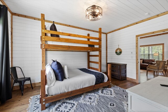 bedroom featuring wood walls and wood finished floors
