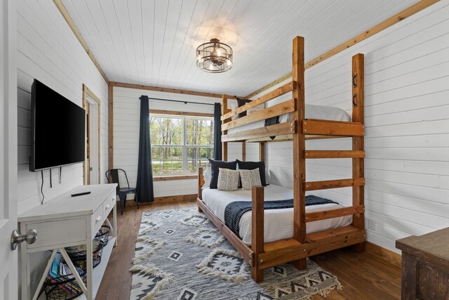 bedroom with wood walls, wood finished floors, and wooden ceiling