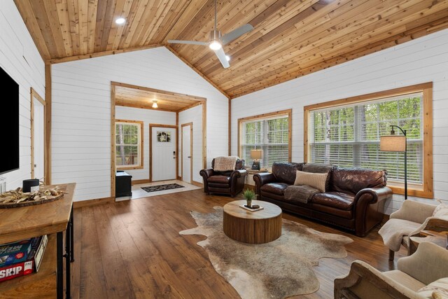 living room featuring ceiling fan, wood walls, lofted ceiling, and hardwood / wood-style floors