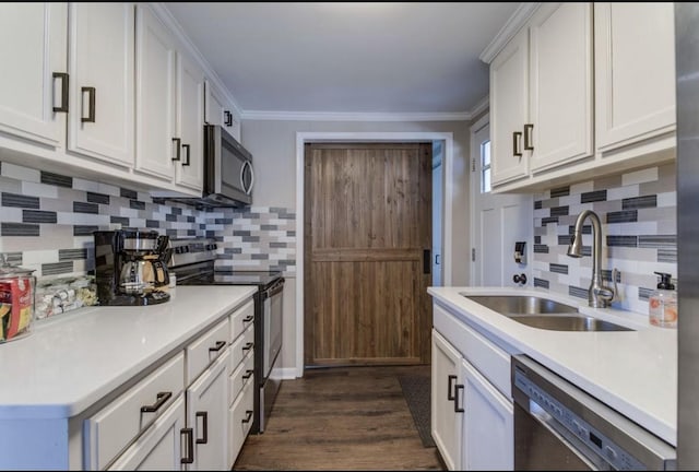 kitchen featuring white cabinets, stainless steel appliances, decorative backsplash, and a sink