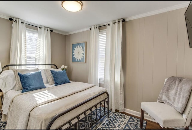 bedroom with baseboards, ornamental molding, and wood finished floors