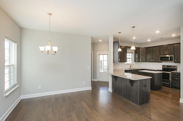 kitchen with stainless steel appliances, dark wood-style flooring, and dark brown cabinets