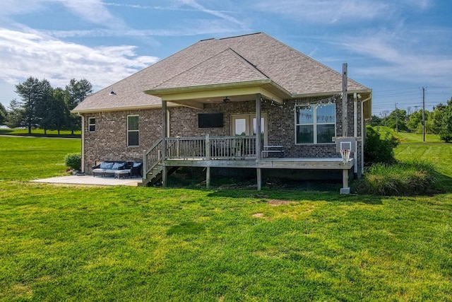 back of house featuring roof with shingles, a deck, a patio area, a lawn, and a ceiling fan