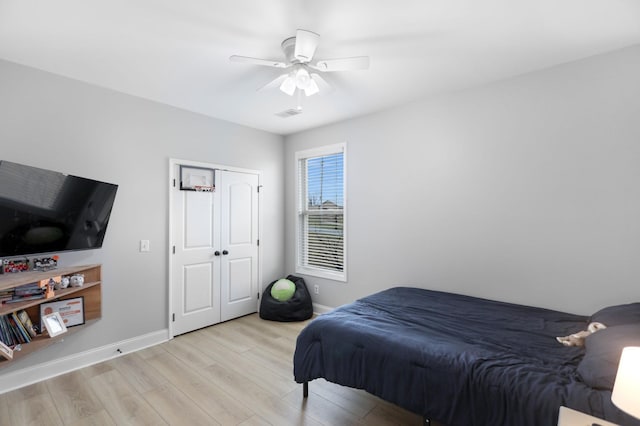 bedroom featuring baseboards, ceiling fan, light wood finished floors, and visible vents