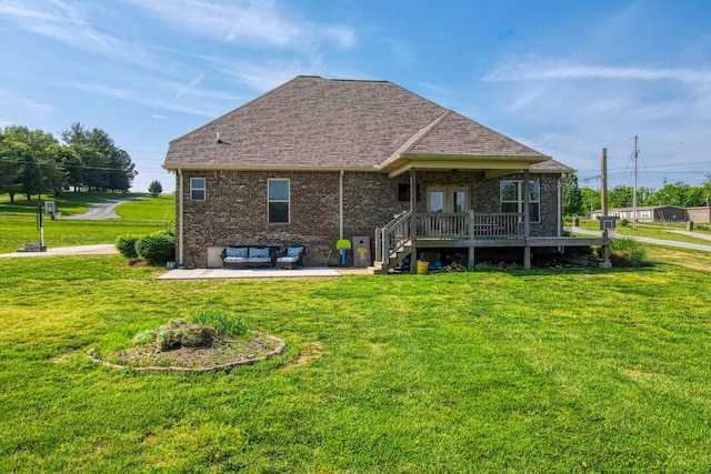 rear view of house with a lawn, a patio, and roof with shingles