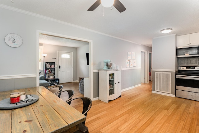 7205 Birchbark Dr, Fairview, TN 37062 - kitchen featuring stainless steel appliances, light wood-style floors, ceiling fan, wainscoting, and ornamental molding