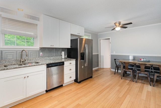 7205 Birchbark Dr, Fairview, TN 37062 - kitchen with appliances with stainless steel finishes, light wood finished floors, a ceiling fan, white cabinetry, and light stone countertops