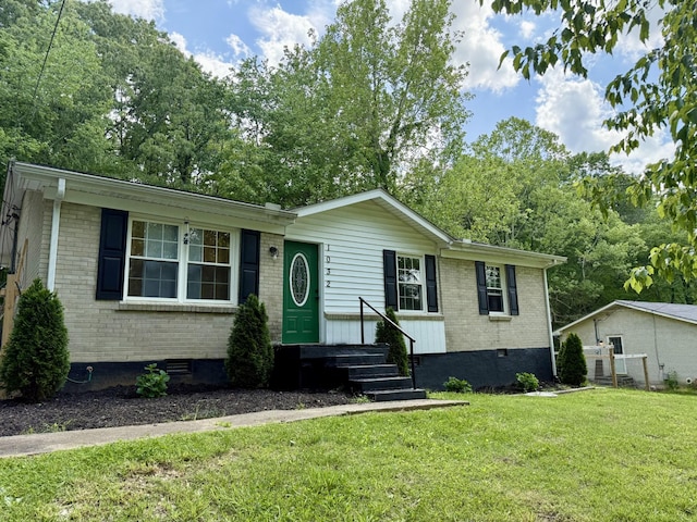 view of front of house with brick siding, crawl space, and a front lawn