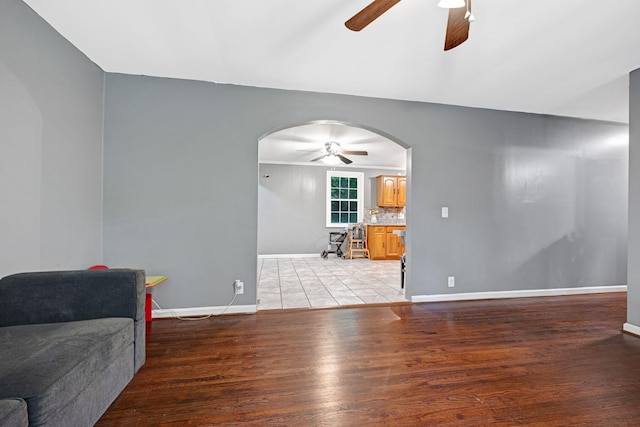 1032 Gordon Cir, Burns, TN 37029 - unfurnished living room featuring ceiling fan, arched walkways, light wood-type flooring, and baseboards