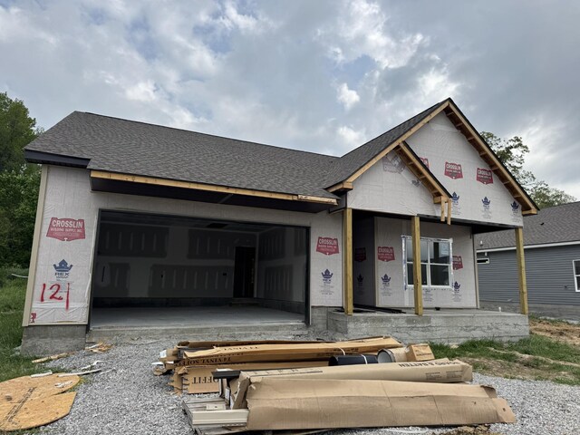 property in mid-construction featuring a garage, roof with shingles, and driveway