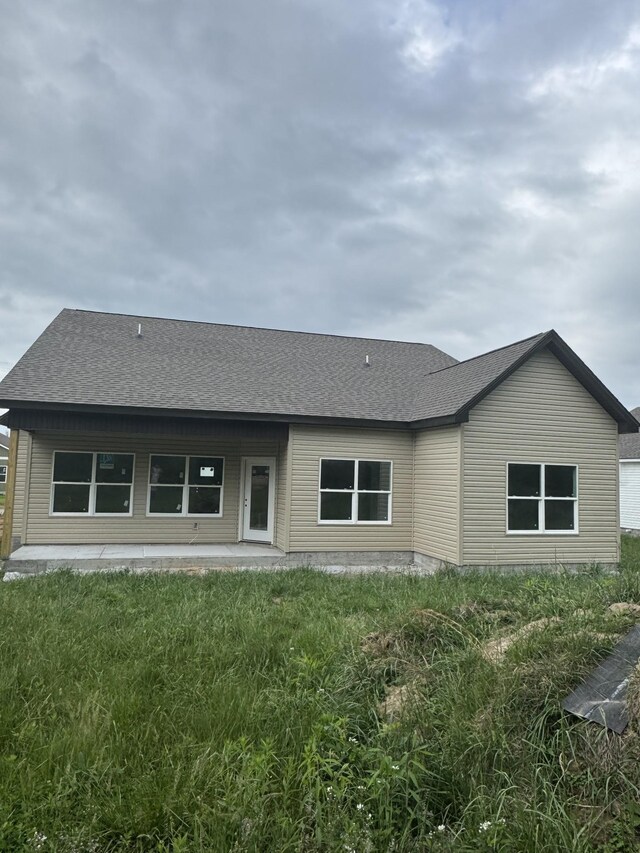rear view of property with a patio and a shingled roof