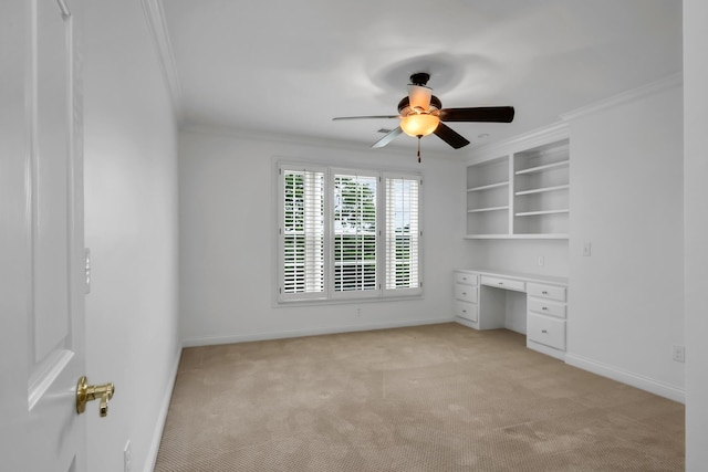 unfurnished bedroom with crown molding, baseboards, light colored carpet, and built in study area