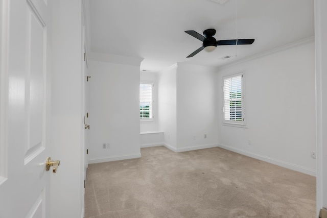 empty room with crown molding, a ceiling fan, light colored carpet, and a wealth of natural light