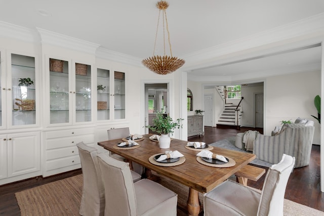 dining space featuring ornamental molding, stairs, and dark wood finished floors