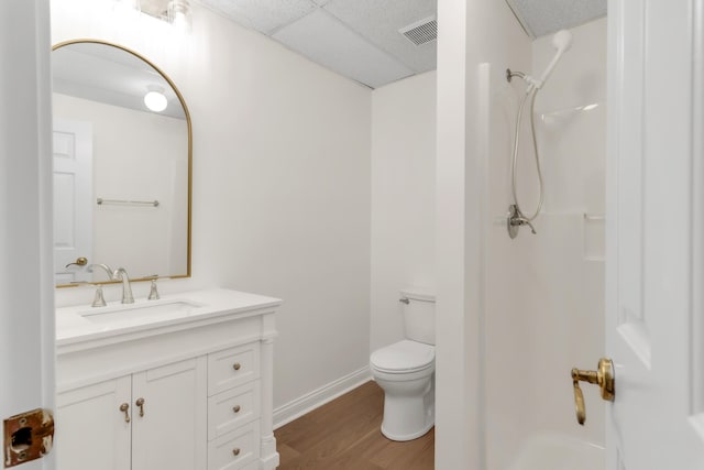 bathroom with visible vents, wood finished floors, a shower, vanity, and toilet