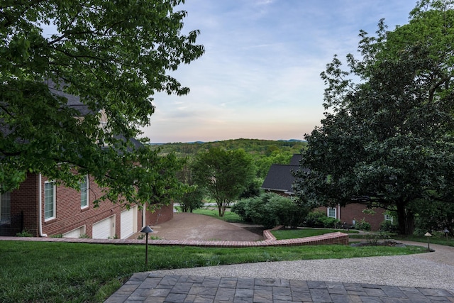 view of community with a yard and an attached garage