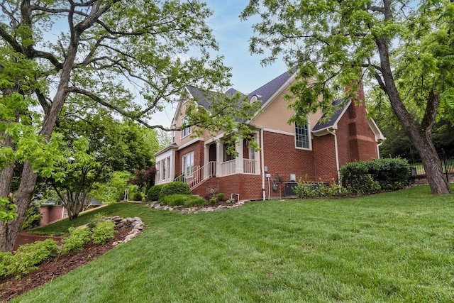 view of side of property with central air condition unit, a yard, and brick siding