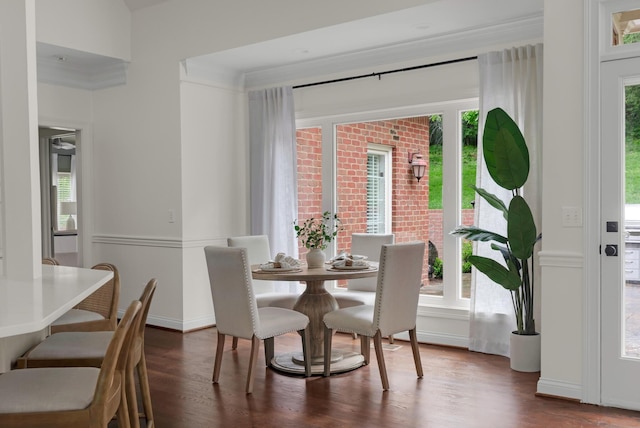 dining space featuring crown molding, plenty of natural light, and wood finished floors
