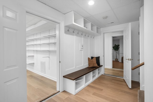 mudroom with a paneled ceiling, baseboards, visible vents, and light wood-style flooring