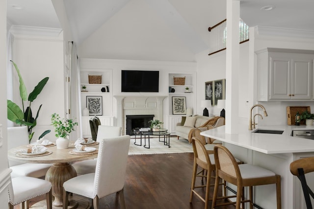 dining space with high vaulted ceiling, a fireplace, dark wood-style floors, and built in shelves