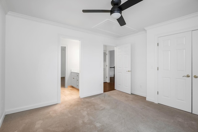unfurnished bedroom with crown molding, attic access, baseboards, and light carpet