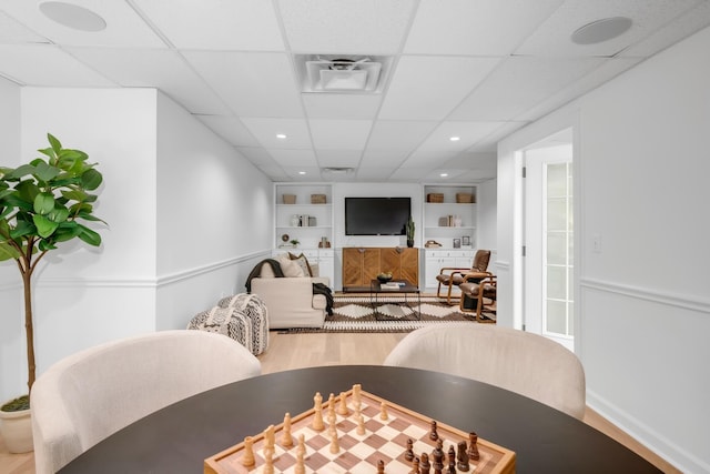 dining space featuring visible vents, built in features, wood finished floors, recessed lighting, and a paneled ceiling