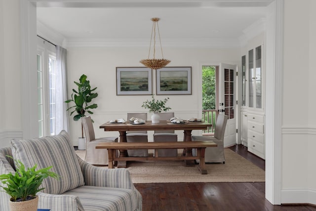 dining area with a healthy amount of sunlight, ornamental molding, and dark wood-style flooring
