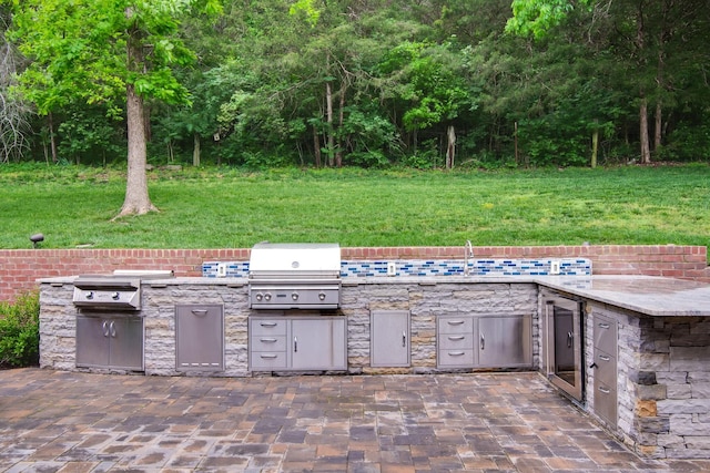view of patio featuring area for grilling, exterior kitchen, and a sink