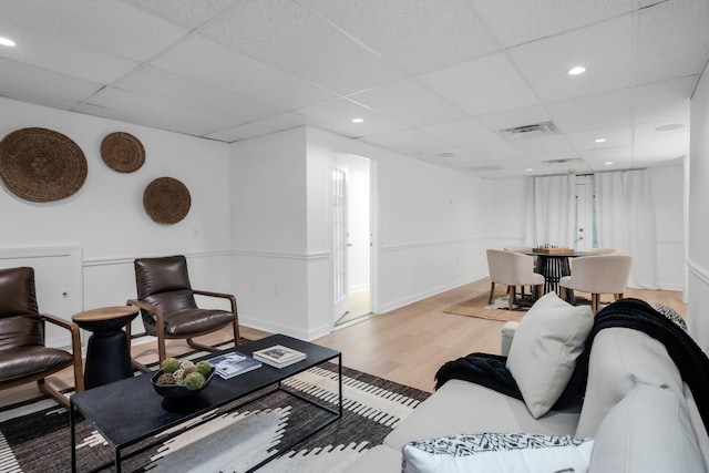 living area with visible vents, recessed lighting, a drop ceiling, and wood finished floors