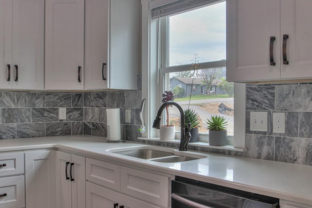kitchen with light countertops, a sink, and dishwasher