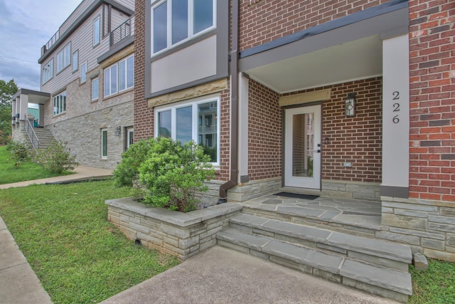 doorway to property featuring brick siding