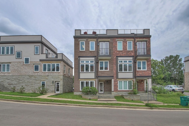 multi unit property with brick siding and a balcony