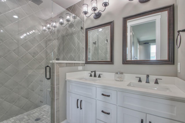 full bathroom with double vanity, a sink, and a stall shower