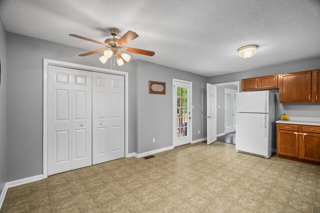3513 Hunters Rdg, Woodlawn, TN 37191 - kitchen featuring freestanding refrigerator, a ceiling fan, a textured ceiling, brown cabinetry, and light floors