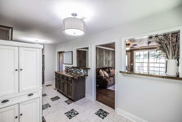 907 N Graycroft Ave, Madison, TN 37115 - kitchen with baseboards, ceiling fan, dark brown cabinetry, and dark stone countertops