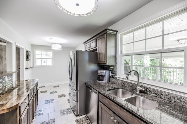 907 N Graycroft Ave, Madison, TN 37115 - kitchen featuring a sink, appliances with stainless steel finishes, baseboards, dark brown cabinets, and backsplash