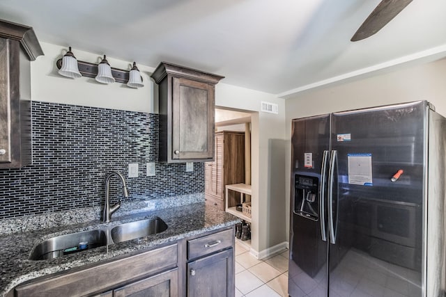 907 N Graycroft Ave, Madison, TN 37115 - kitchen with black fridge, a sink, light tile patterned flooring, dark stone countertops, and decorative backsplash