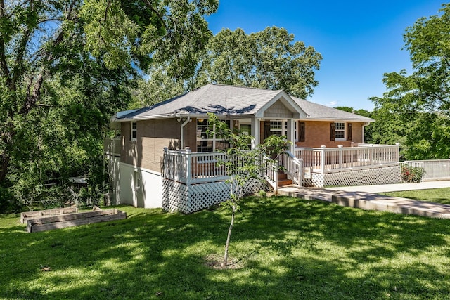 907 N Graycroft Ave, Madison, TN 37115 - view of front facade featuring a vegetable garden, brick siding, a wooden deck, and a front lawn