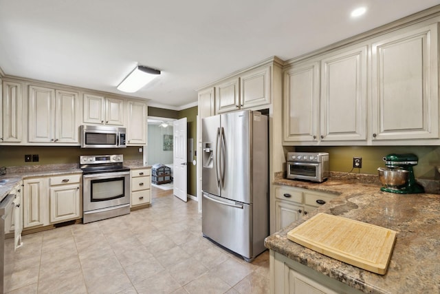 206 Evergreen Dr, Columbia, TN 38401 - kitchen with appliances with stainless steel finishes, a toaster, ornamental molding, light tile patterned flooring, and cream cabinetry