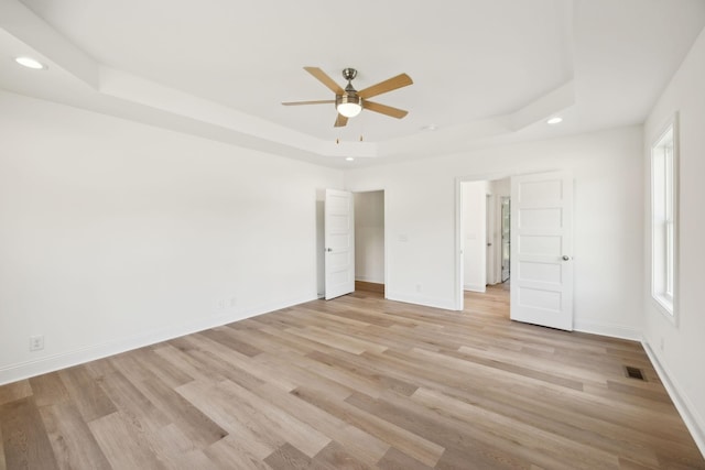 1065 Gholson Rd, Clarksville, TN 37043 - unfurnished bedroom featuring recessed lighting, light wood-style floors, a tray ceiling, and multiple windows