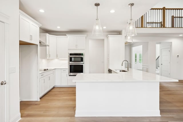 1065 Gholson Rd, Clarksville, TN 37043 - kitchen with stainless steel double oven, a sink, black electric cooktop, light wood-style flooring, and white cabinetry