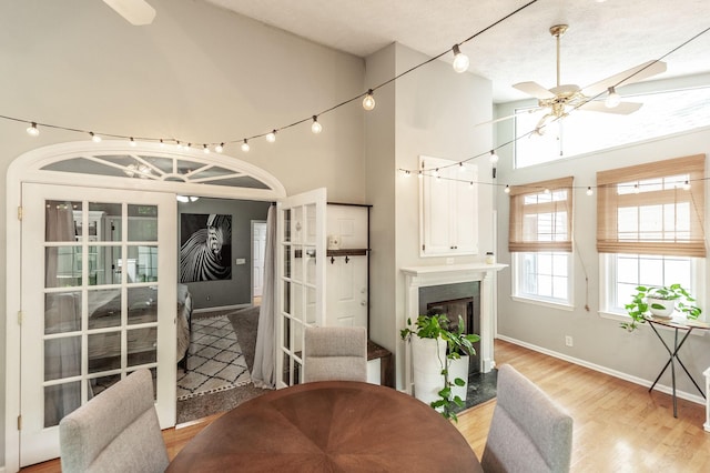 1505 Newmans Trl, Hendersonville, TN 37075 - dining room with ceiling fan, baseboards, high vaulted ceiling, light wood finished floors, and a glass covered fireplace